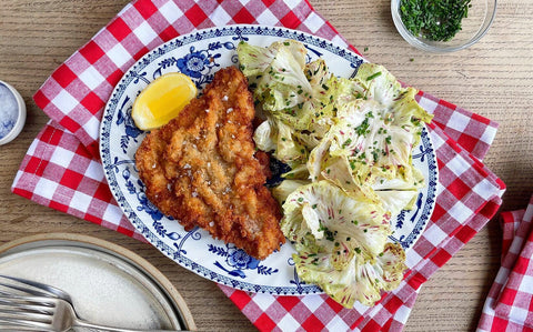 Crispy milk-fed veal schnitzel served with fresh lemon-dressed Castelfranco leaves