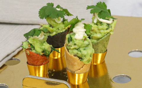 Guacamole and crème fraîche canapé cones garnished with micro coriander
