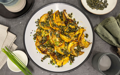 Autumnal acorn squash topped with green chives, pumpkin seeds and sticky truffle honey