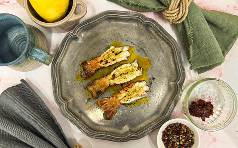 Shiny torched langoustine tails with a vibrant butter spiked with red harissa paste