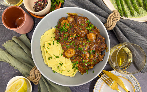 Deeply brown and rich Bœuf Bourguignon with creamy mash and green parsley