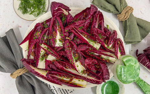 Bright radicchio leaves on a large white serving platter with green chives