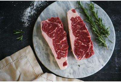 raw wagyu steak on marble with rosemary